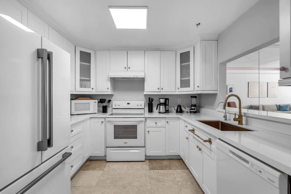Bright, fully equipped kitchen with stainless steel appliances, sleek white cabinetry, and ample counter space—everything you need to cook, entertain, and feel right at home during your stay.