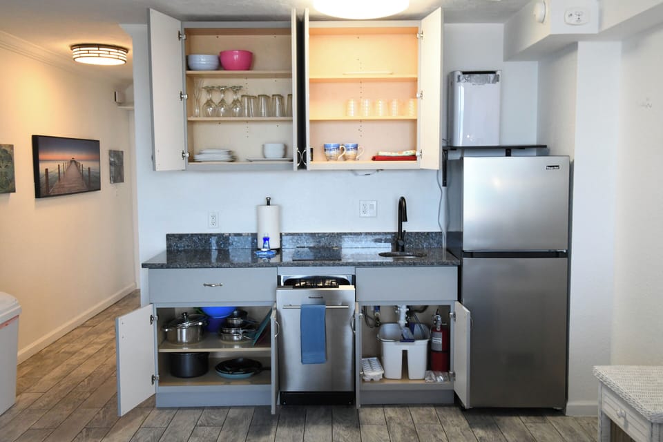 Your kitchenette has everything you need—full-size fridge, dishwasher, pots, pans, dishes, and glassware—all neatly stocked and ready for your stay.