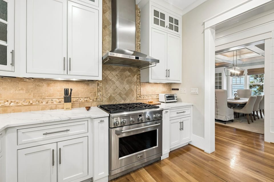 Step into your private chef's dream with gleaming stainless appliances, elegant white cabinetry, and warm wood floors that flow from kitchen to dining. Cook, gather, and make memories in this bright, welcoming space.