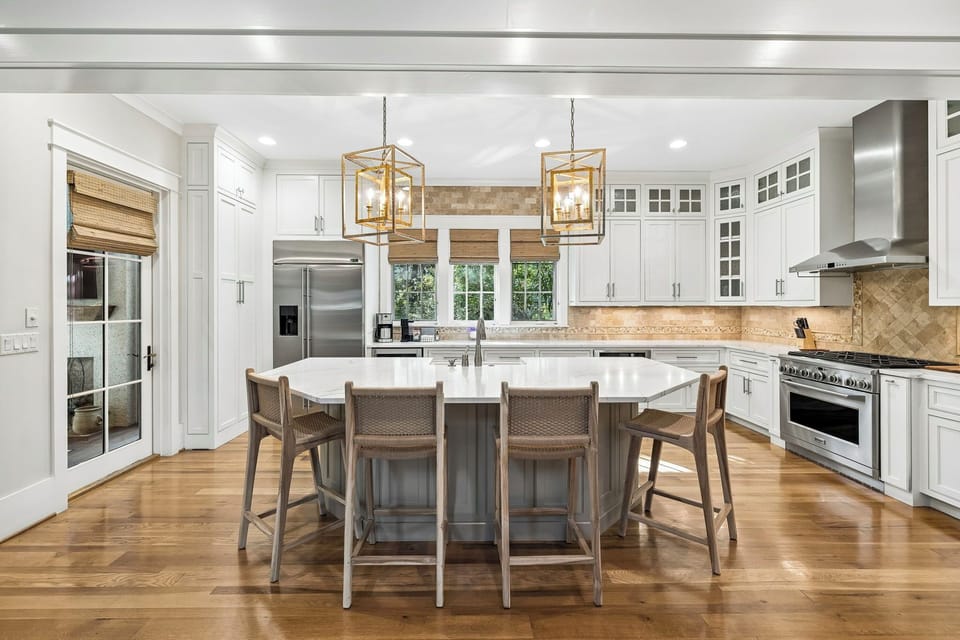Picture yourself preparing meals in this elegant, light-filled kitchen. Gather around the spacious island with family, enjoy gleaming countertops, professional appliances, and warm wood floors that make cooking feel effortless and inviting.