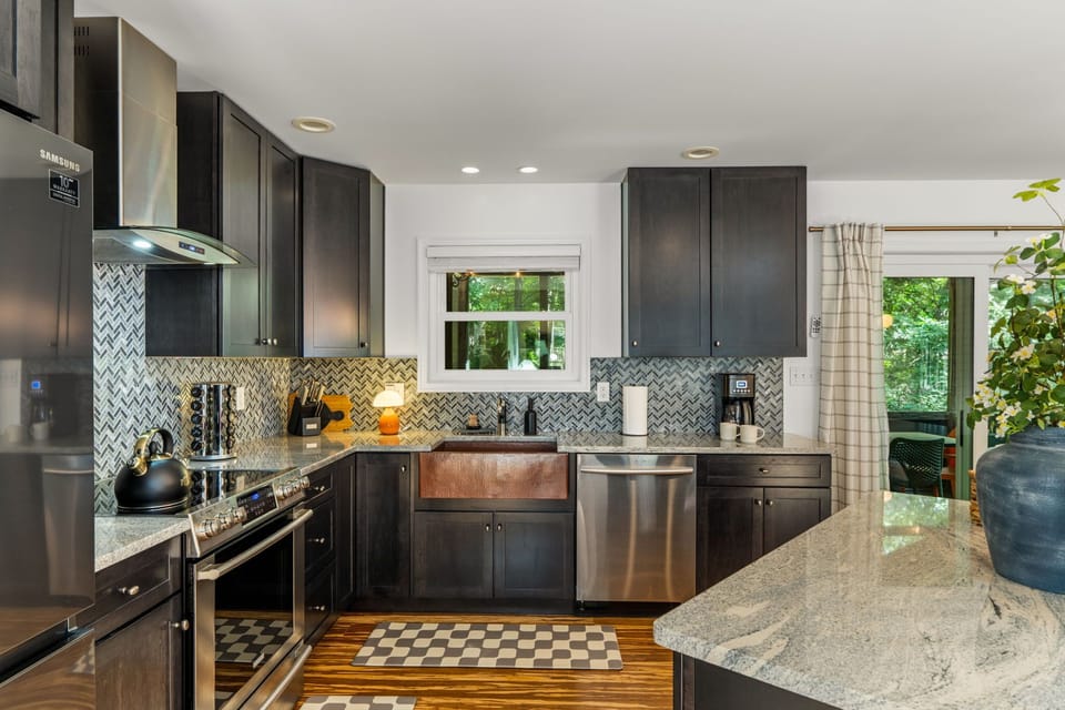 Modern gourmet kitchen with granite island, farmhouse sink, and natural light
