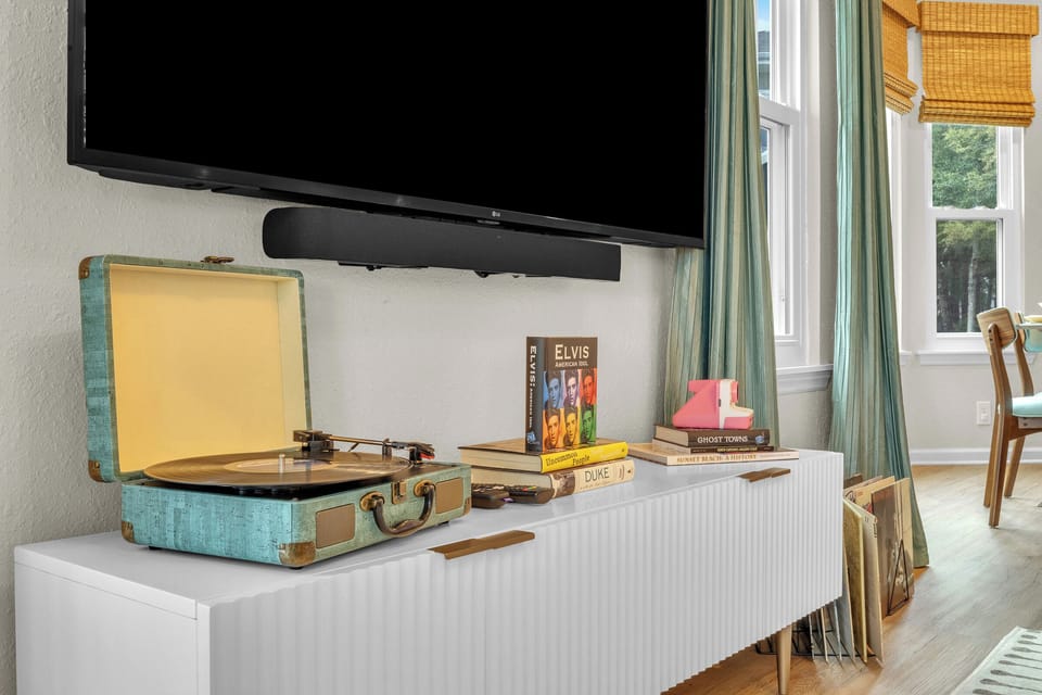 Spin some tunes on the vintage-style record player or catch a movie on the smart TV in this charming, retro-inspired entertainment space.