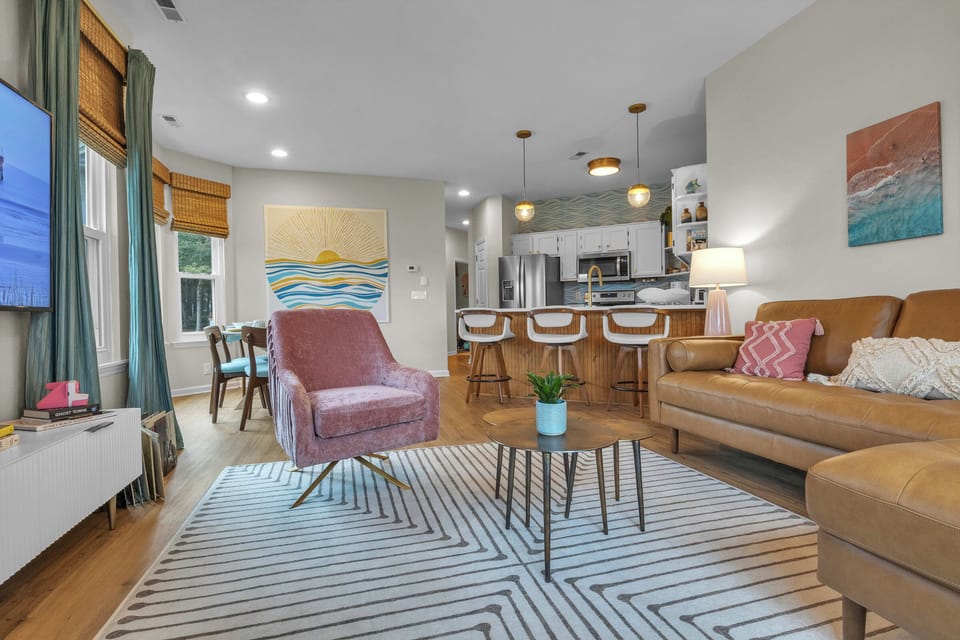Bright open living area with stylish kitchen, bar seating, and cozy lounge