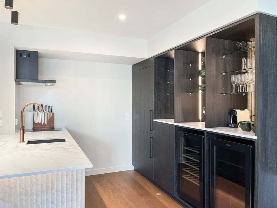 The sleek designer kitchen is fully equipped with quality appliances, a wine fridge, and everything you need to dine in.