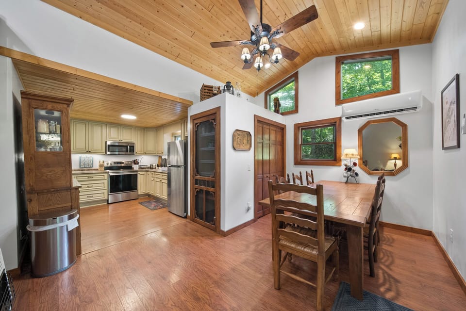 Open kitchen and dining area with warm wood details and abundant natural light