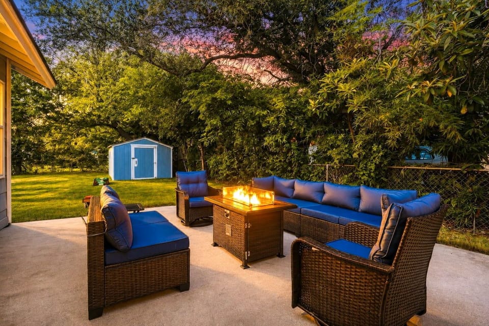 Cozy backyard patio with fire table, lounge seating, and lush green views