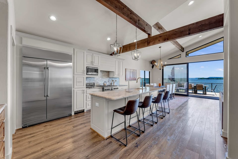 Fully equipped kitchen w/ wine cooler, island seating for 4, & panoramic lake views
