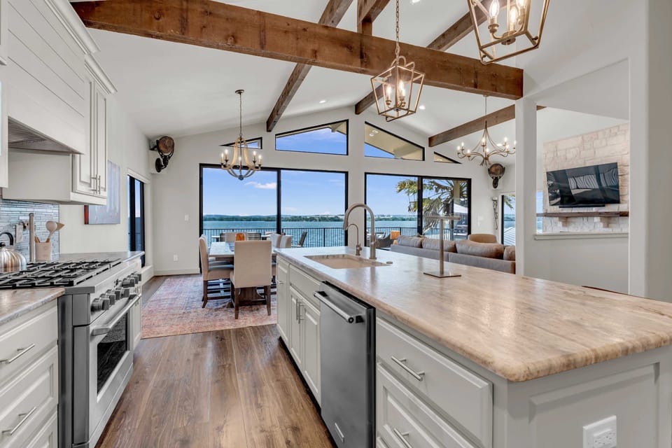 Fully equipped kitchen w/ wine cooler, island seating for 4, & panoramic lake views