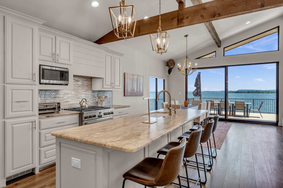 Fully equipped kitchen w/ wine cooler, island seating for 4, & panoramic lake views