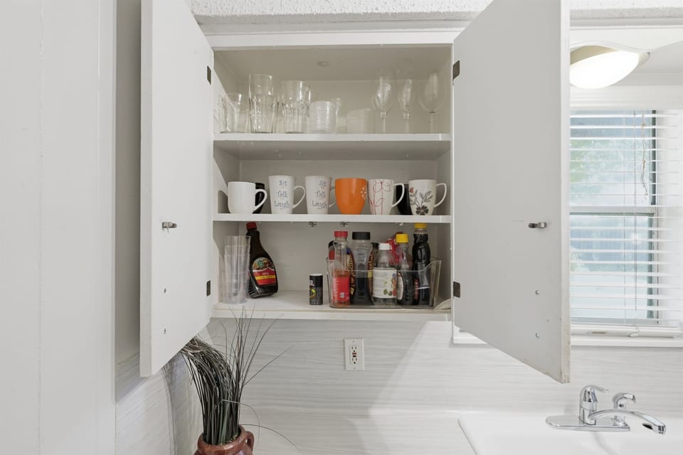 Bright and functional kitchen stocked with cookware, dishes, and cooking essentials.
