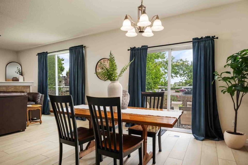 A dedicated dining space with a wooden dining table, classic chandelier lighting, and glass sliding doors leading out to the patio.