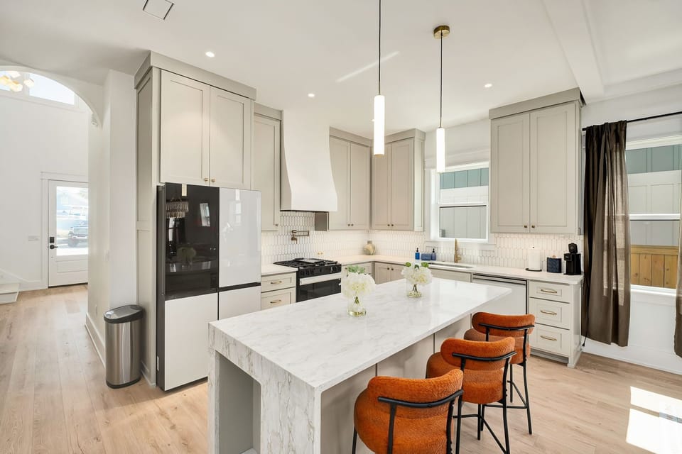 Bright designer kitchen with waterfall island and stylish seating