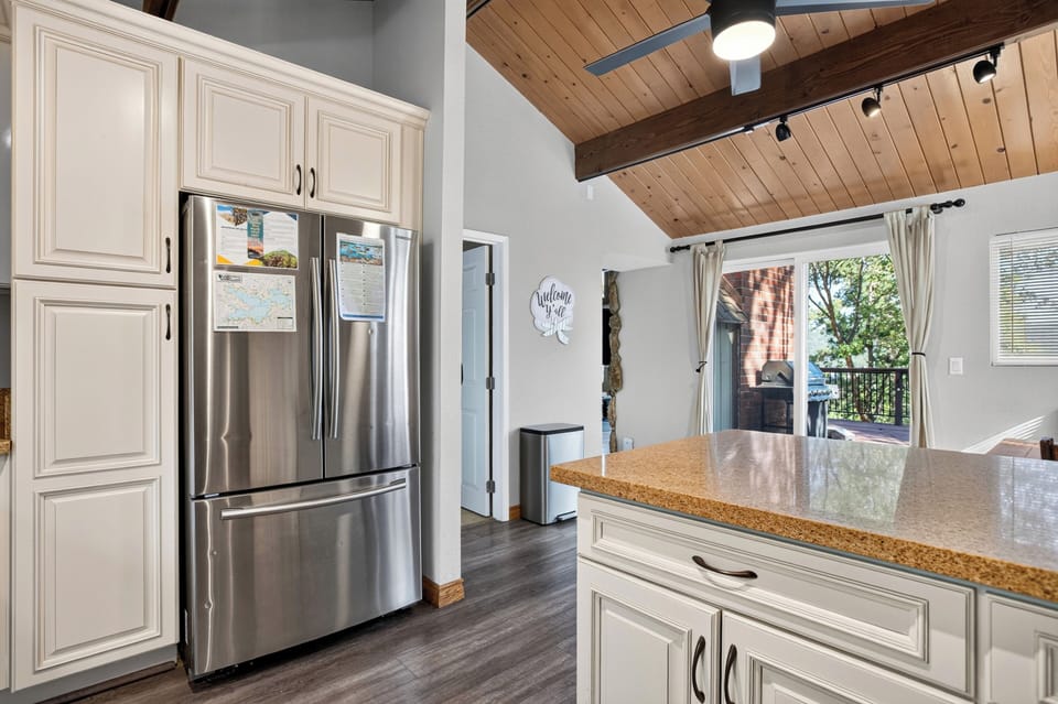 View of the kitchen island, refrigerator, and outdoor access.
