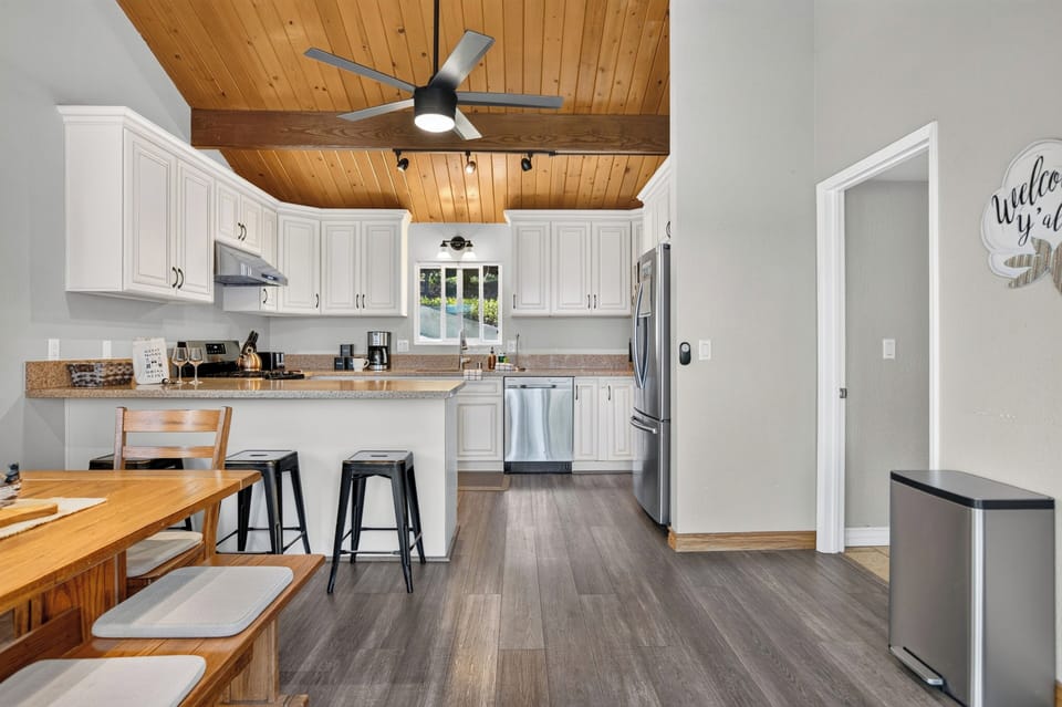 Modern kitchen featuring stainless steel appliances and wood ceilings.