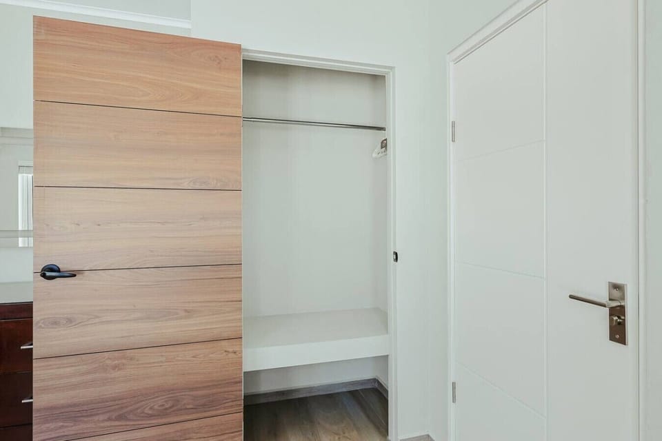 Bedroom 4 includes a spacious built-in closet with a sliding wood door, hanging space, and overhead shelving for convenient storage.