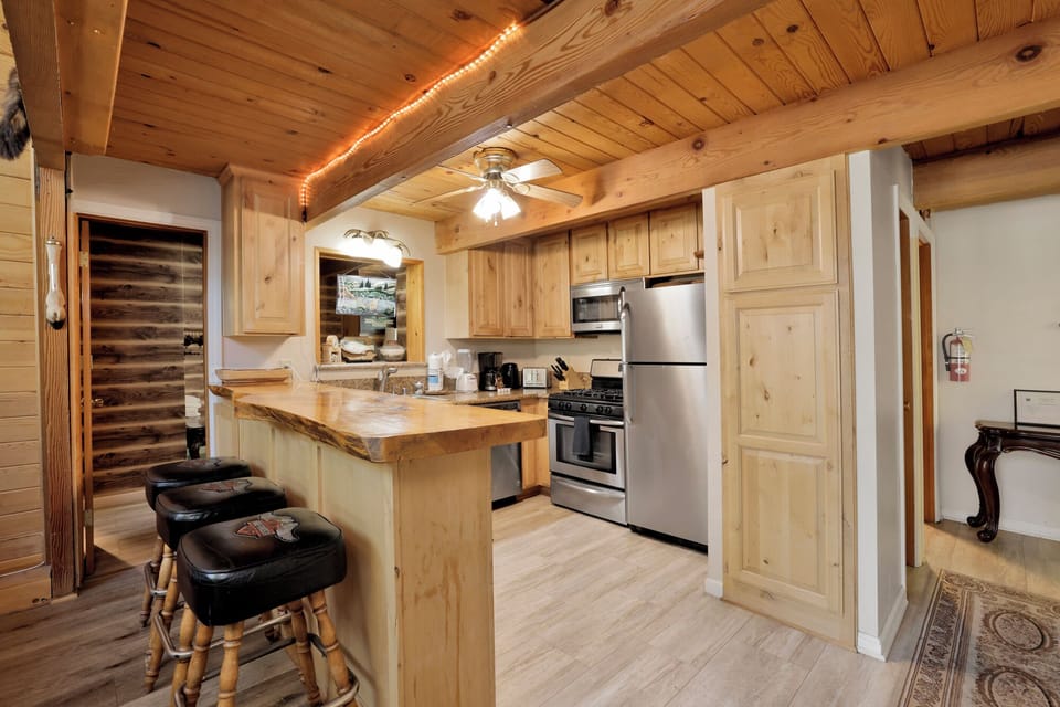 Fully equipped cabin kitchen with ample cabinetry, stove, fridge, and coffee maker—perfect for cooking meals, morning coffee, and feeling right at home on your stay.