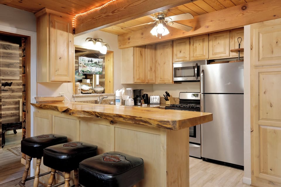 Fully equipped cabin kitchen with ample cabinetry, stove, fridge, and coffee maker—perfect for cooking meals, morning coffee, and feeling right at home on your stay.