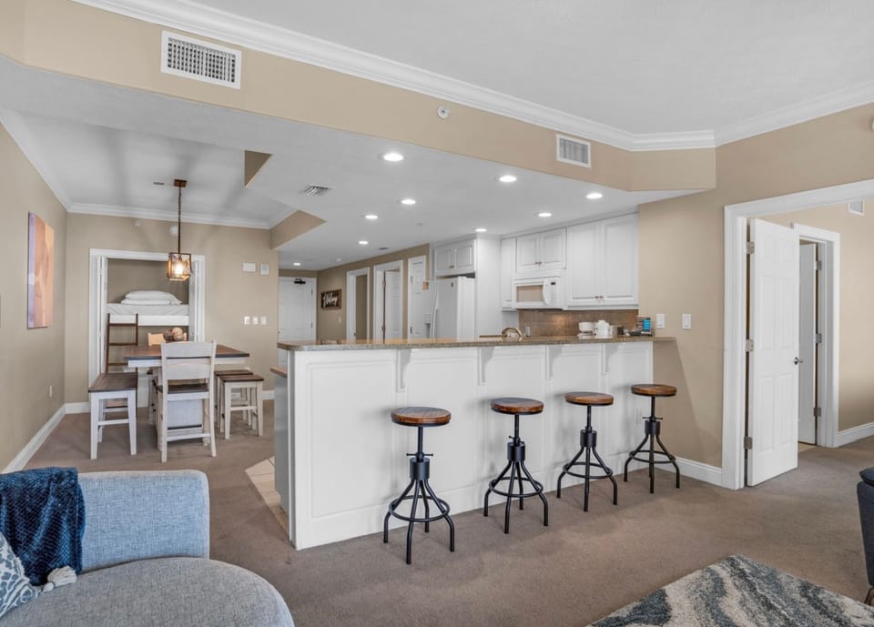 Step into your open-concept retreat where the kitchen, dining, and living areas flow seamlessly together. Gather at the breakfast bar, share meals at the dining table, or unwind on the cozy sofa—your perfect home base awaits.
