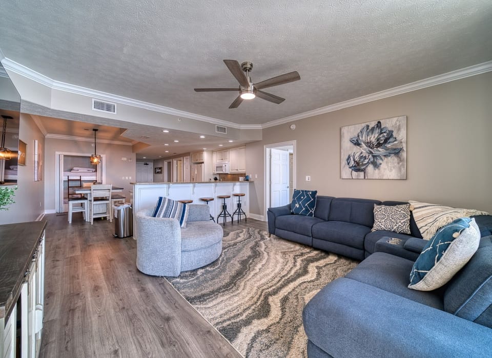 Settle into your spacious open-concept living area, where plush sectional seating, modern artwork, and a stylish swirl rug invite you to unwind after exploring nearby attractions.