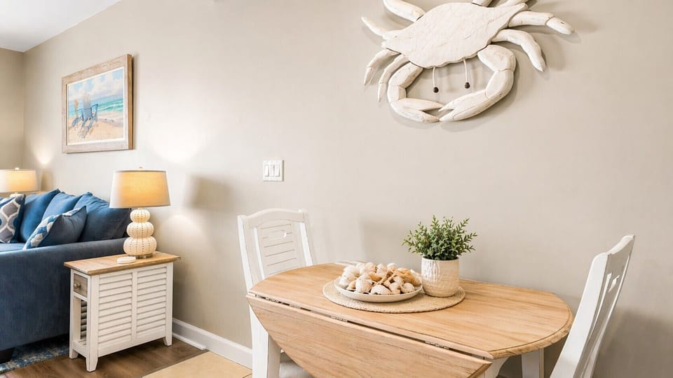 Gather around this charming dining nook where coastal accents and warm wood tones create your perfect spot for morning coffee or casual meals together.