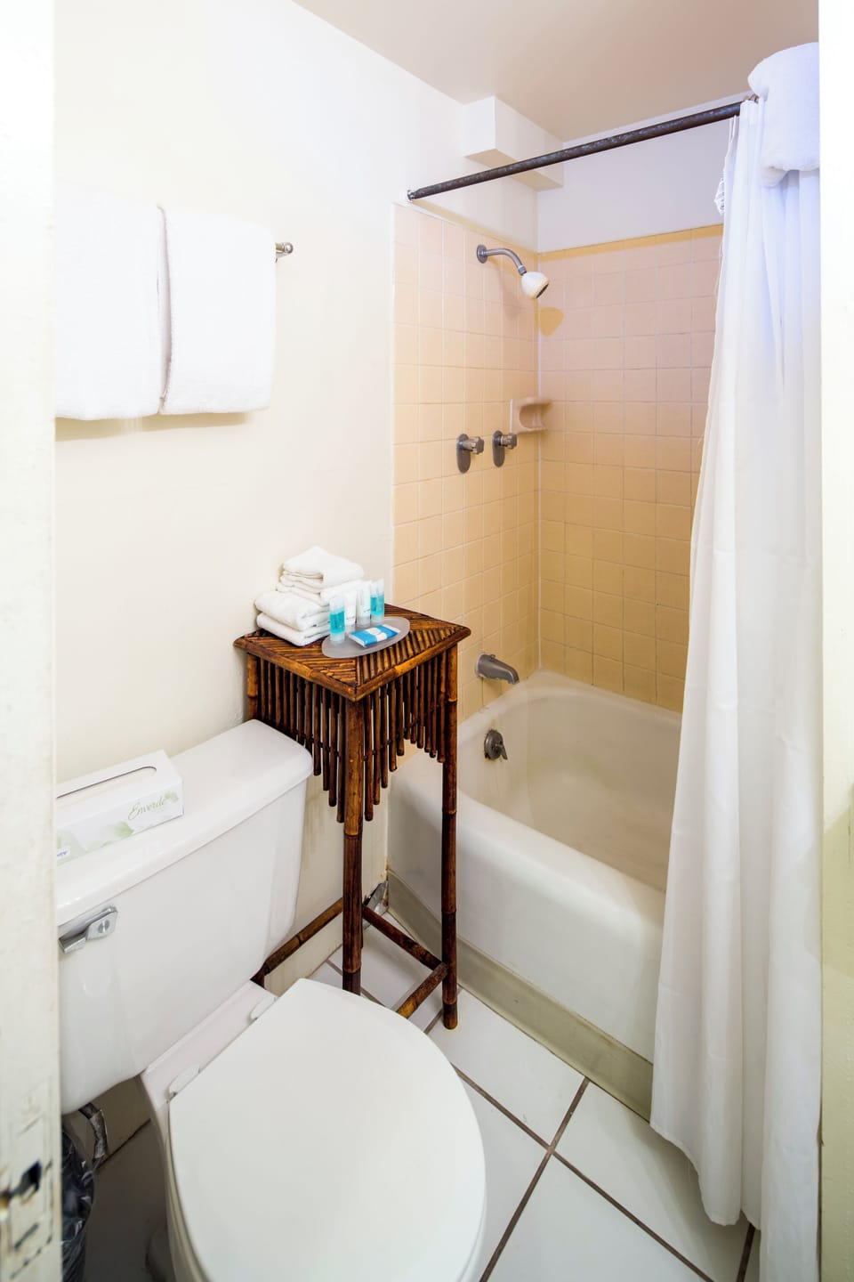 Step into your private bathroom with a cozy tub-shower combo, fresh towels, and essentials neatly arranged for your comfort and convenience.