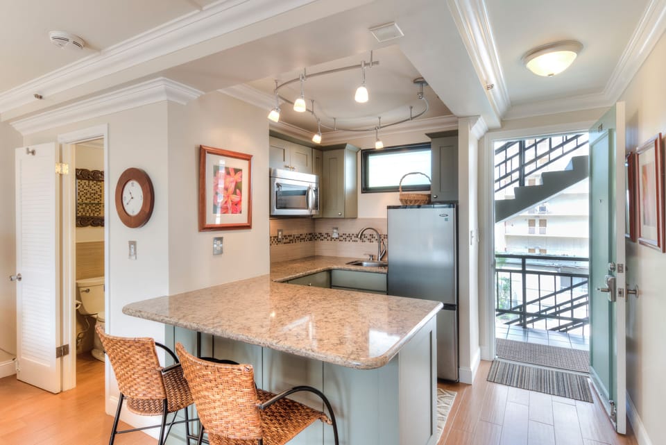Your well-equipped kitchen features granite counters, stainless appliances, a breakfast bar with seating, and stylish track lighting—perfect for easy meal prep during your stay.