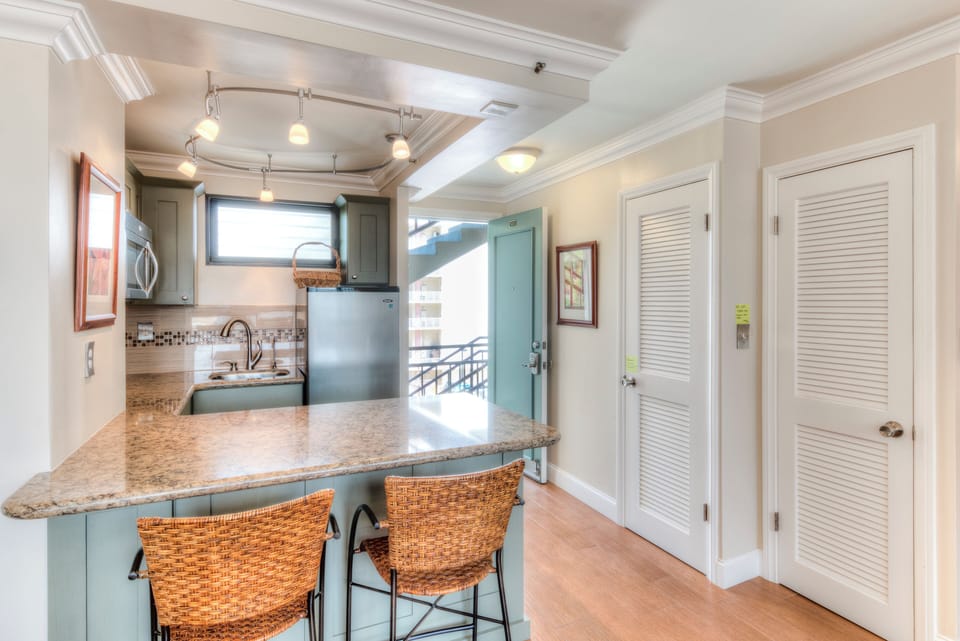 Gather at the breakfast bar with granite countertops and coastal charm, where your mornings start with style and modern appliances are at your fingertips.