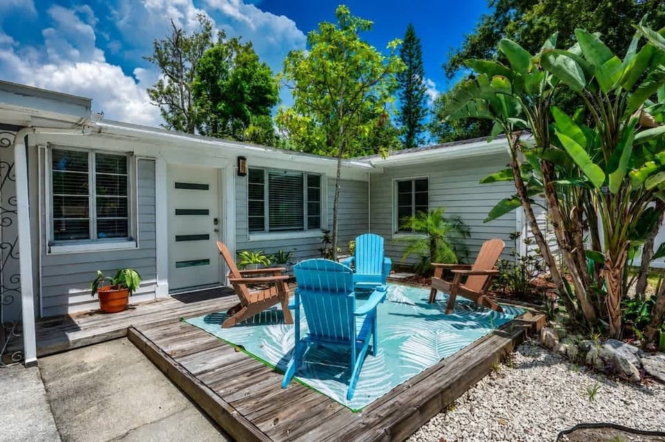 Private fenced backyard with mature trees, shade, and outdoor seating