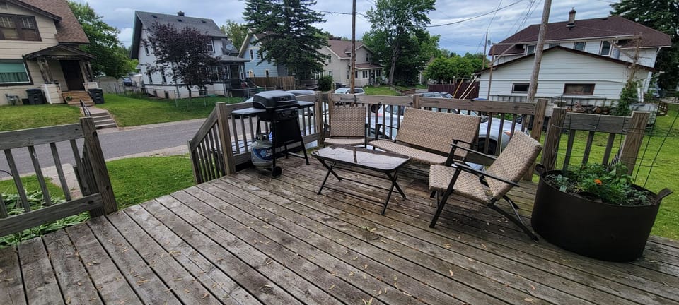 Back deck has seating and a propane grill.