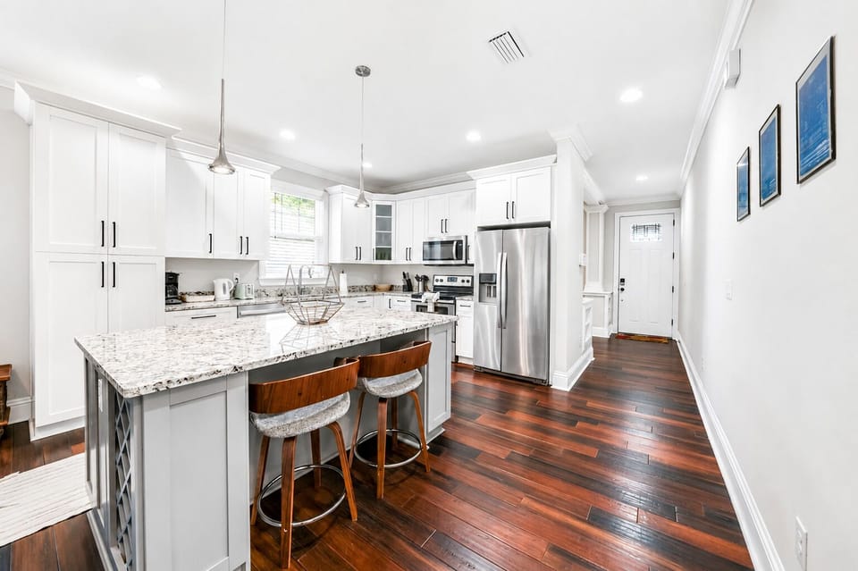 Cook with ease in the modern kitchen featuring granite countertops, stainless steel appliances, and bar seating.