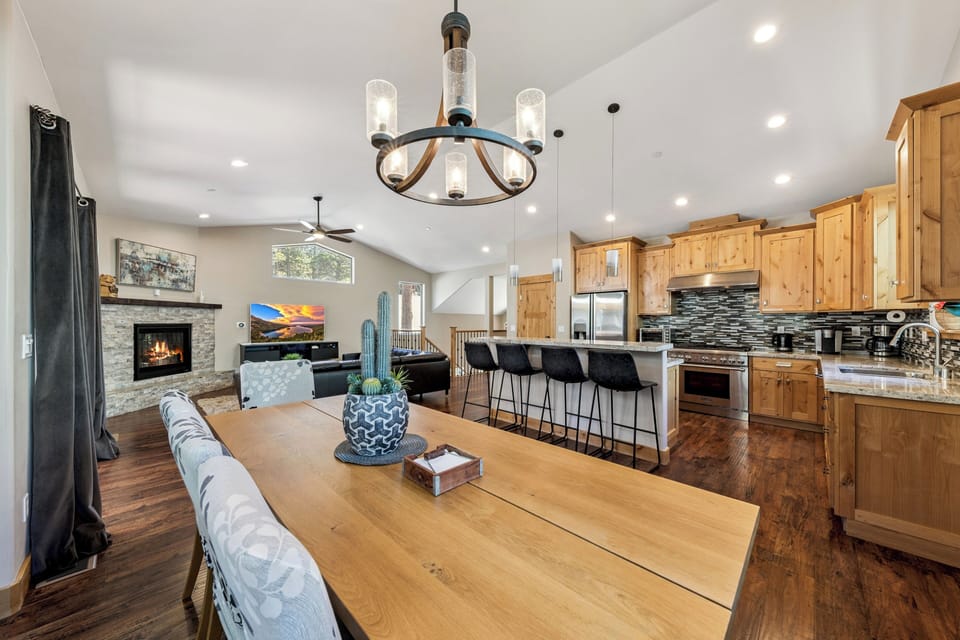 Step into your bright, open great room where rustic wood meets modern comfort. Gather around the dining table with mountain views, then unwind by the fireplace or whip up a feast in your fully-equipped kitchen.