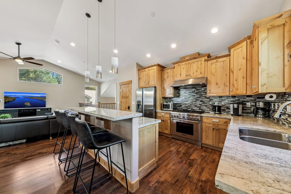 Your open-concept kitchen and living space invites you to gather, cook, and unwind, all in one beautifully designed area. Warm wood cabinetry and modern appliances make cooking a joy while you stay connected with guests.