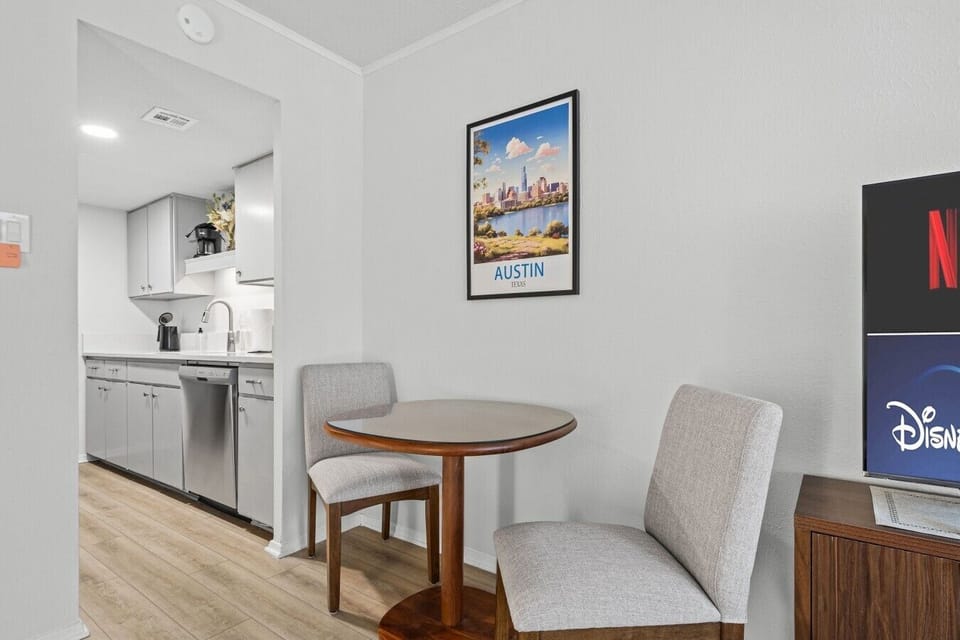 Enjoy morning coffee at the bistro dining table, steps from the galley kitchen and framed by local Austin art.