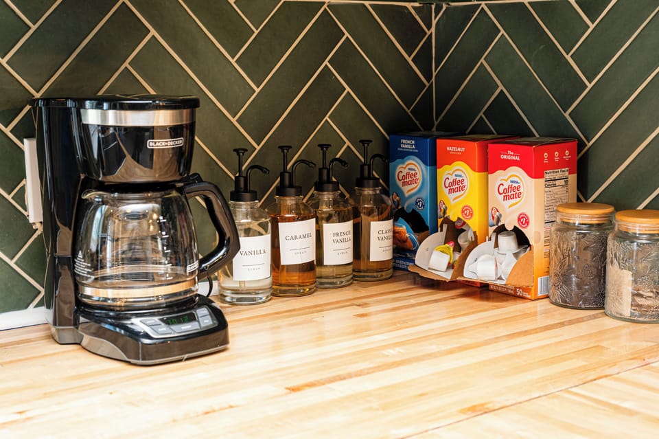 Chic coffee bar with syrups, creamers, and a drip brewer—morning ready!