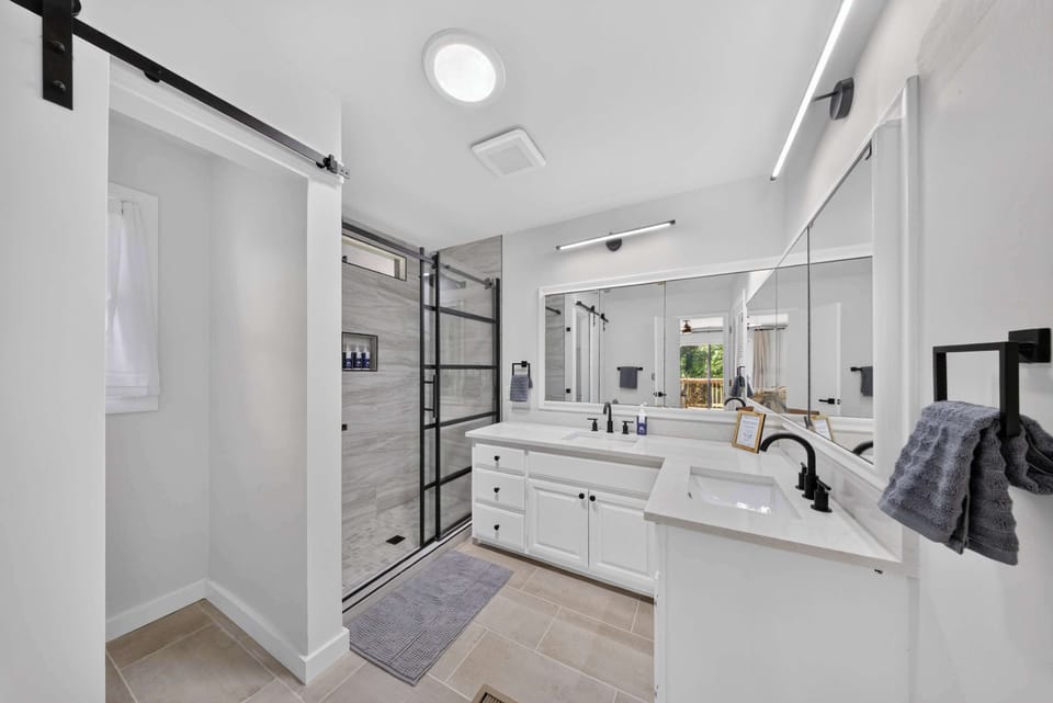 Primary ensuite full bathroom with a double vanity and glass walk-in shower