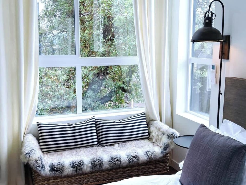 Master suite with king bed, double closet, ensuite bathroom, and a peaceful view of the heritage madrone tree in the courtyard