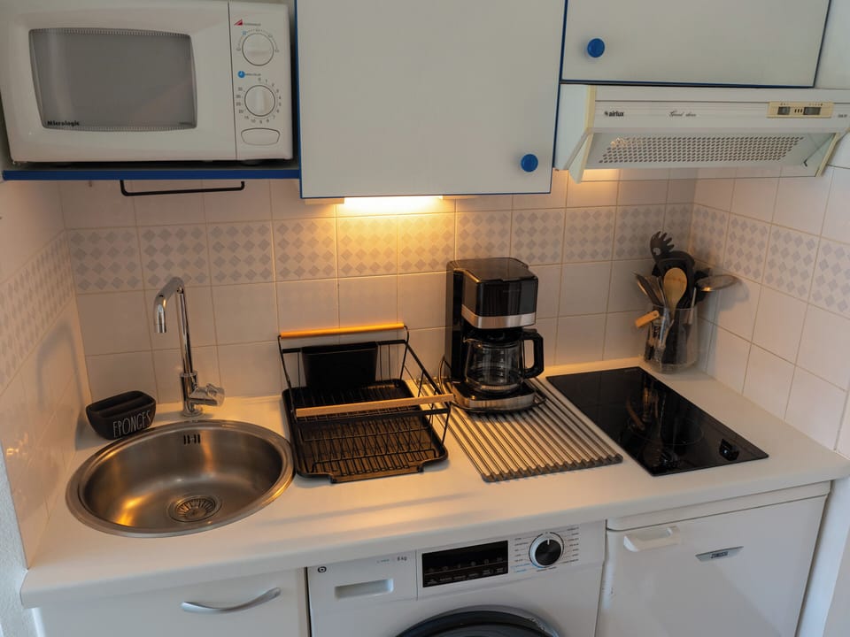 Fully equipped kitchen with a drip coffee maker, microwave, washing machine... 