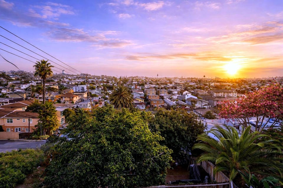 Panoramic sunset cityscape with palms from a hillside retreat
