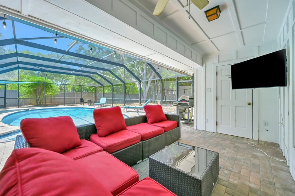 Outdoor sectional with TV overlooking the screened pool