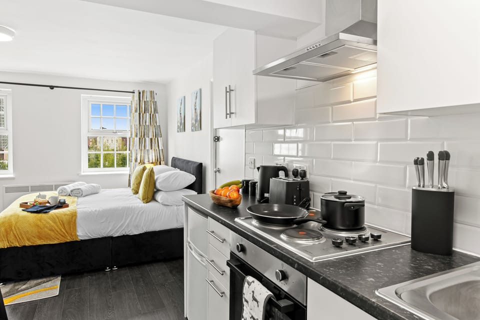 Modern studio with stocked kitchenette, cozy bed & sunny windows