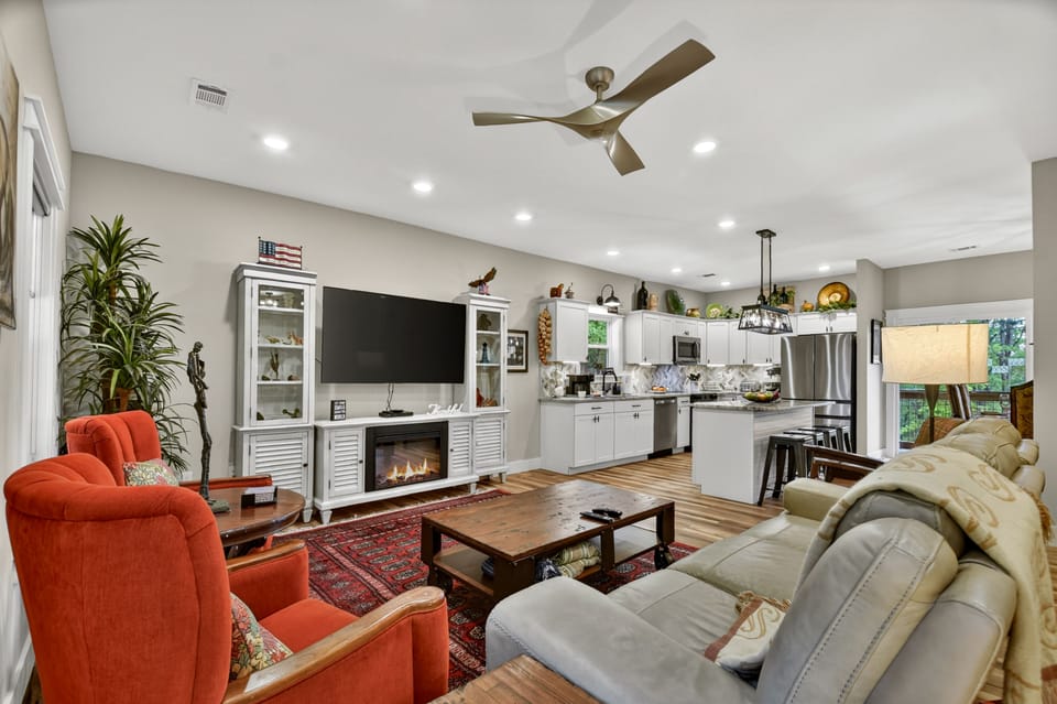 Cozy open-concept living area with a large TV and fireplace at this relaxing Ellijay cabin rental
