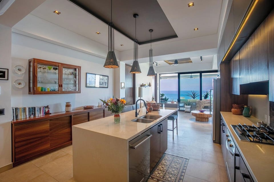 Sleek kitchen whit warm wood tones and elegant stone countertops
