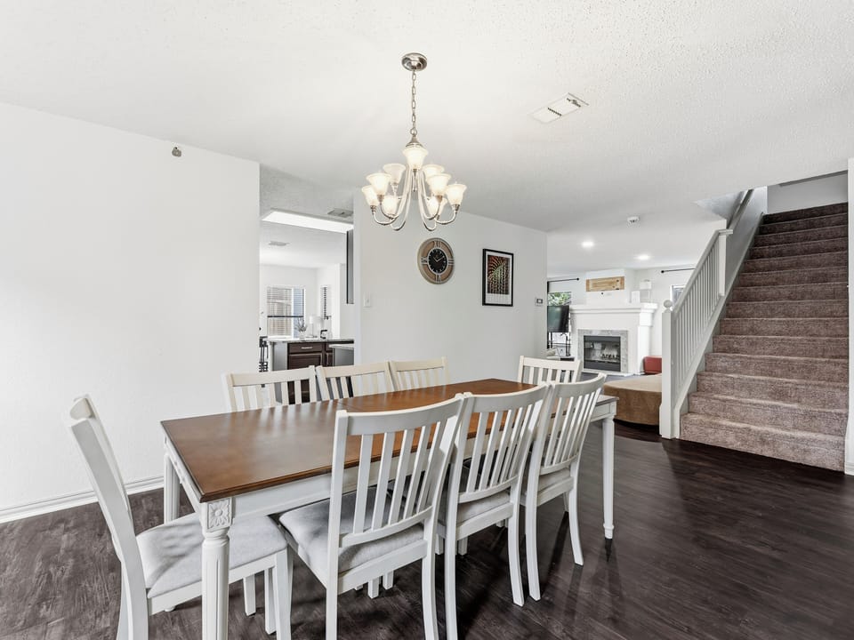 Gather around this spacious dining table with seating for ten, perfect for sharing meals and making memories together under the elegant chandelier.