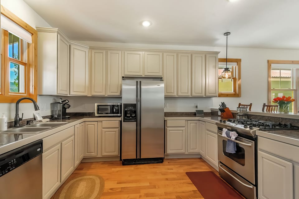 Your fully equipped kitchen features stainless steel appliances, ample counter space, and elegant cream cabinetry—perfect for preparing meals during your stay.