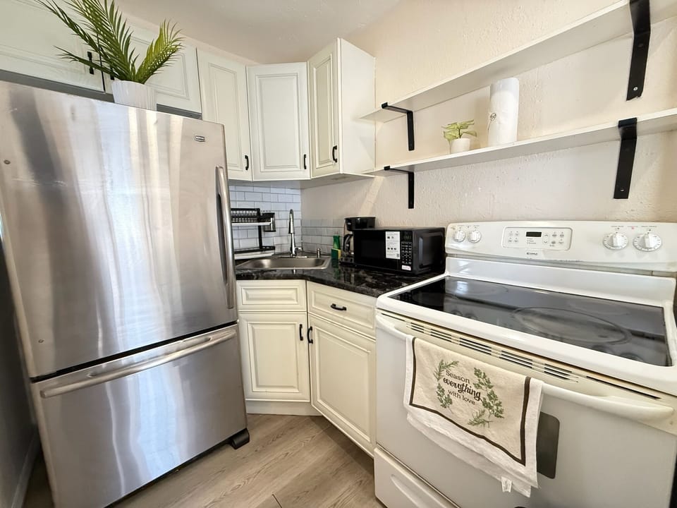 Bright modern kitchen with stainless appliances and stylish open shelving