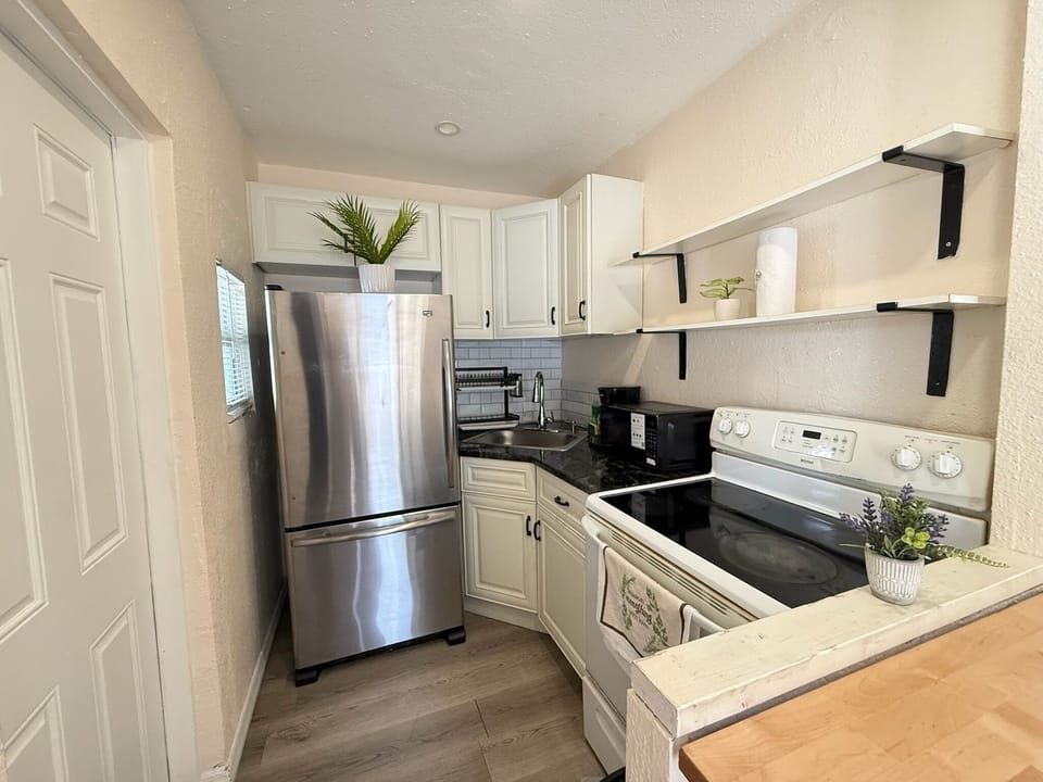 Bright updated kitchen with stainless appliances and stylish open shelving