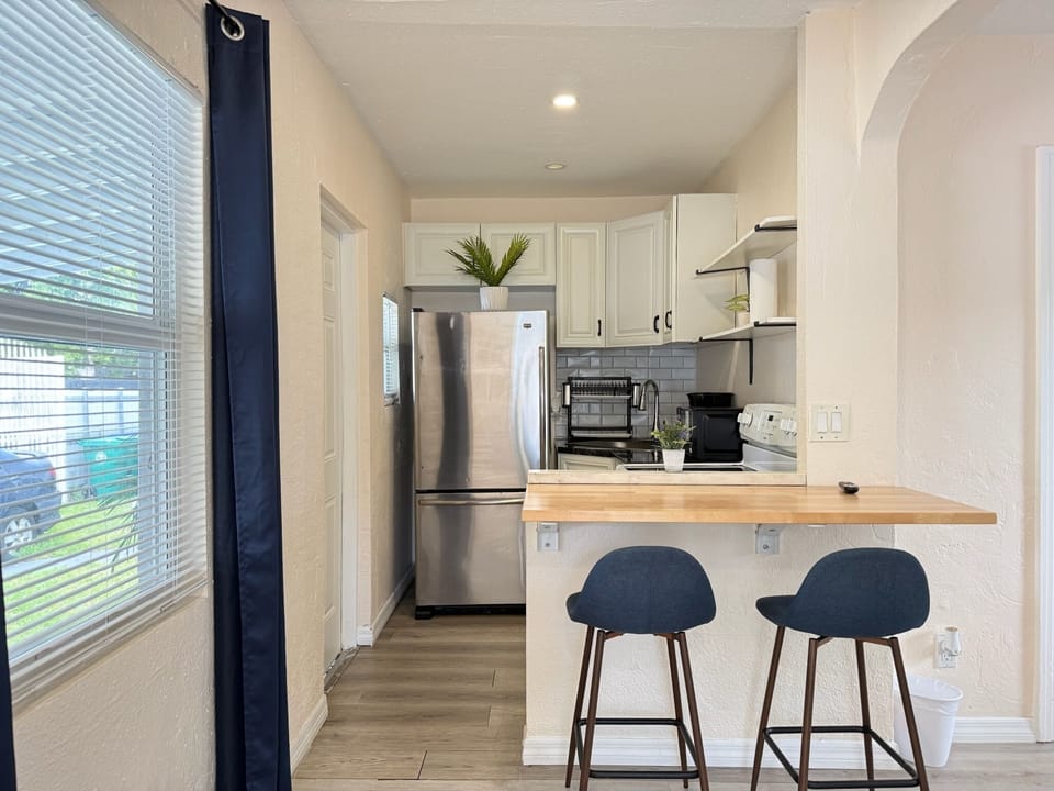 Bright modern kitchen with breakfast bar and stainless steel appliances