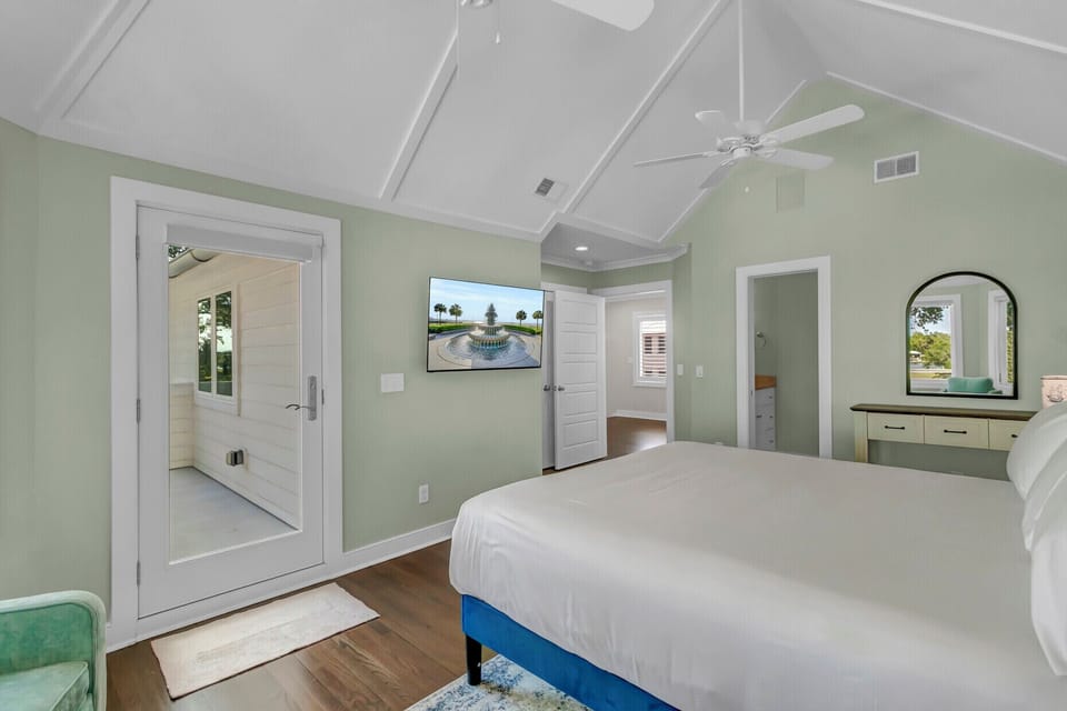 Unwind in your serene retreat with soaring vaulted ceilings, calming sage-green walls, and gleaming hardwood floors. Fresh linens invite restful sleep while the gentle ceiling fan keeps you cool.