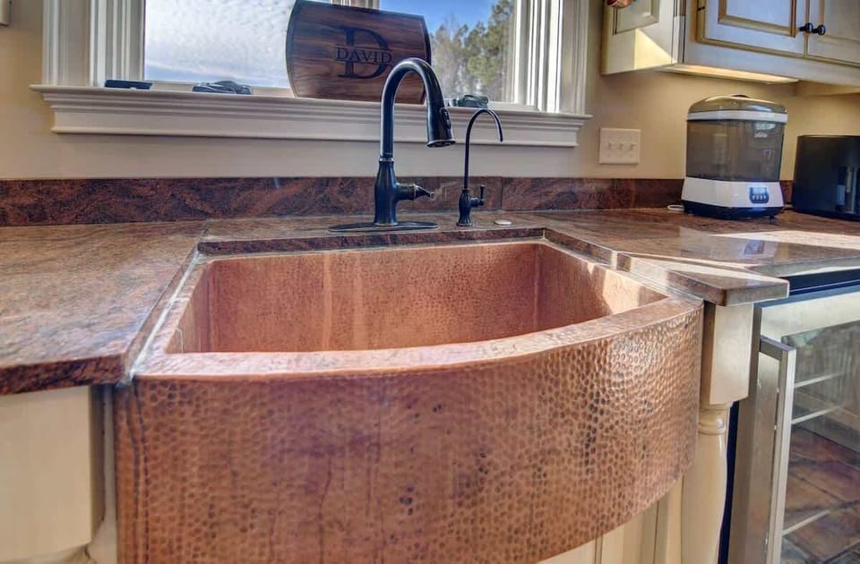 Stunning copper farmhouse sink — a unique touch in the fully equipped kitchen.