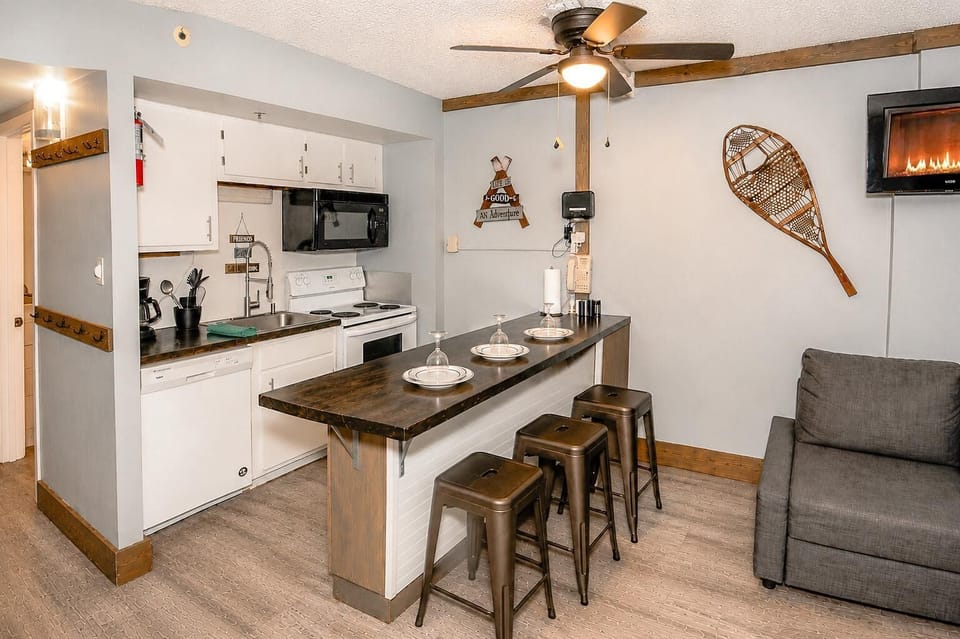 Stove, dishwasher, full sink, and microwave included in the kitchen, as well as a wood top bar to enjoy homecooked meals!